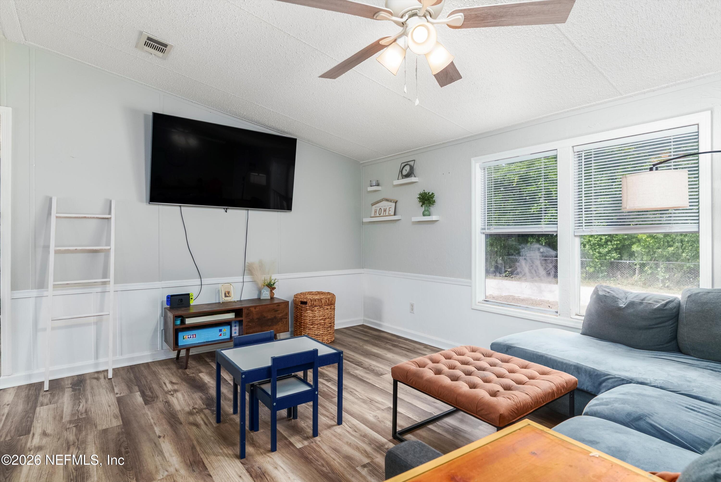 85246 Johnson Lane Yulee, FL 32097 - Photo 6 of 46 a living room with furniture a flat screen tv and a window