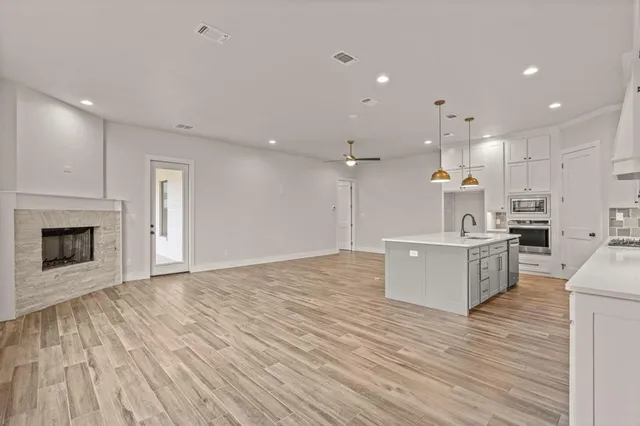 a large kitchen with a lot of counter space and a wooden floor