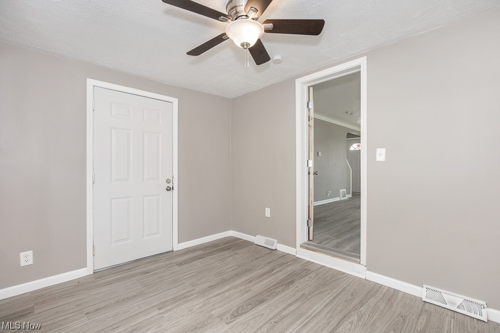 19109 Libby Road Maple Heights, OH 44137 - Photo 6 of 32 Unfurnished bedroom featuring ceiling fan, light hardwood / wood-style floors, and a textured ceiling