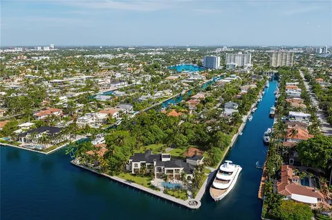 an aerial view of residential houses with outdoor space and trees