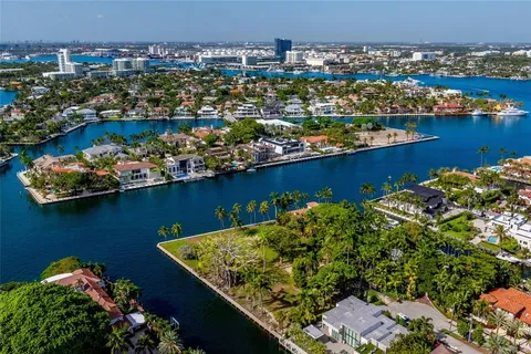 an aerial view of a residential house with outdoor space and trees all around