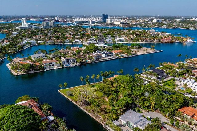 an aerial view of a residential house with outdoor space and trees all around