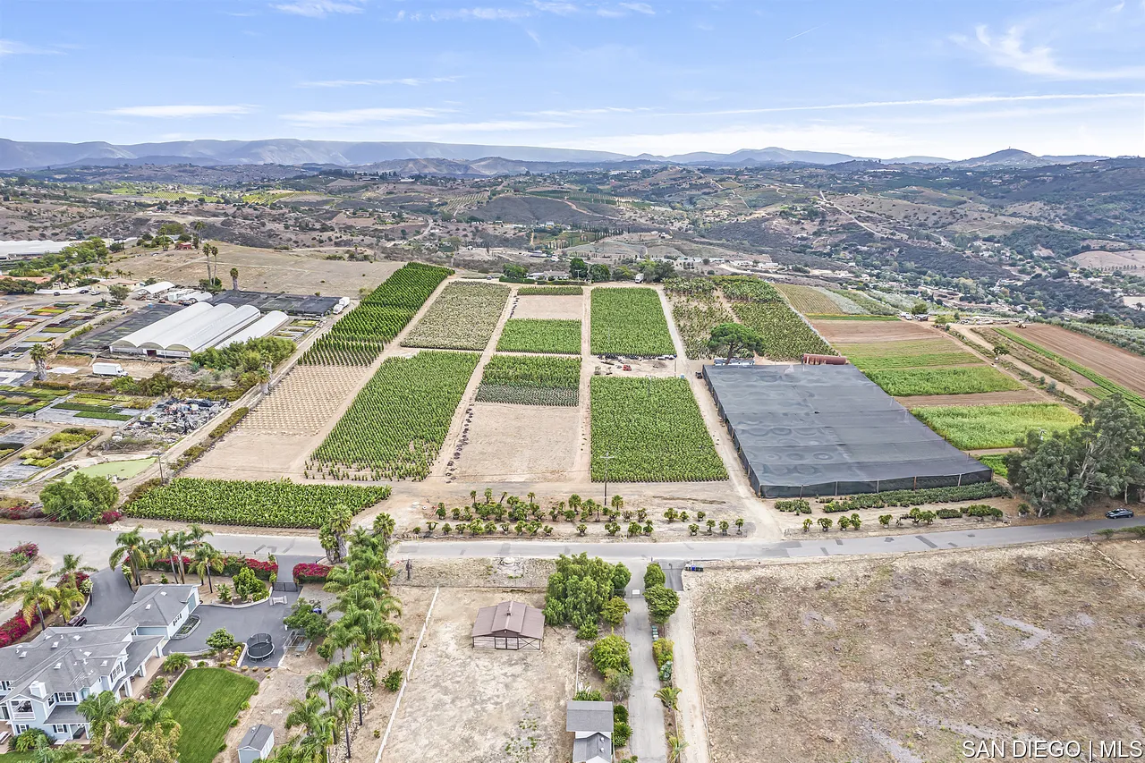 an aerial view of residential houses with outdoor space and swimming pool