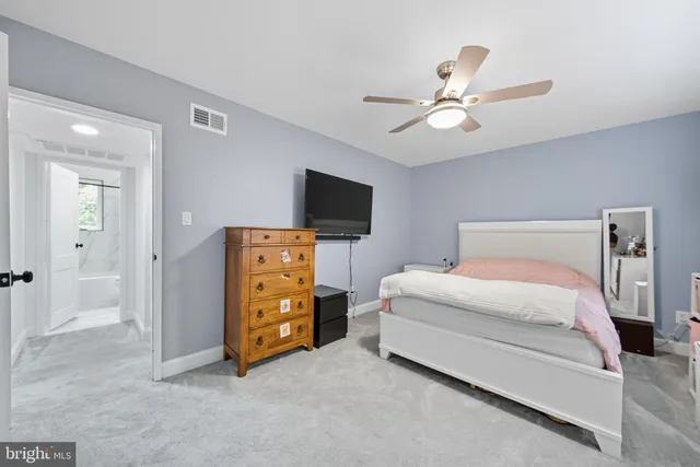 a spacious bedroom with a bed and a flat screen tv