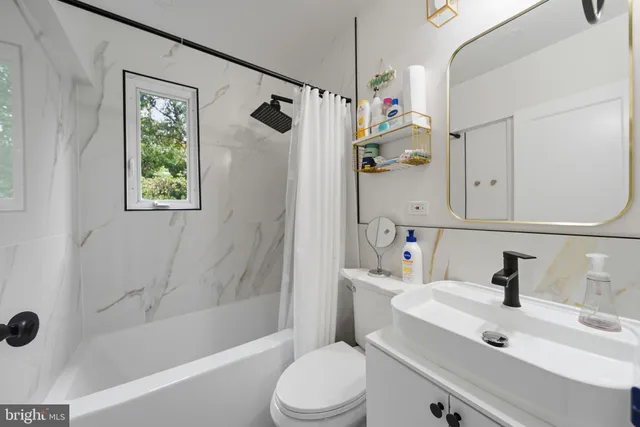 a bathroom with a sink toilet tub and shower