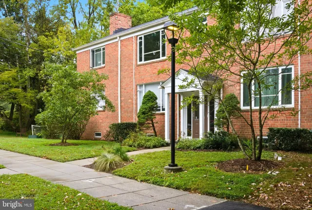 a front view of a house with a yard and potted plants