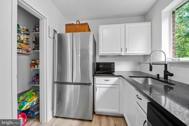 a kitchen with stainless steel appliances granite countertop a refrigerator and a sink