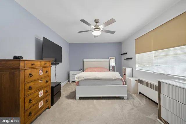 a bedroom with a bed and a flat tv screen on the dresser