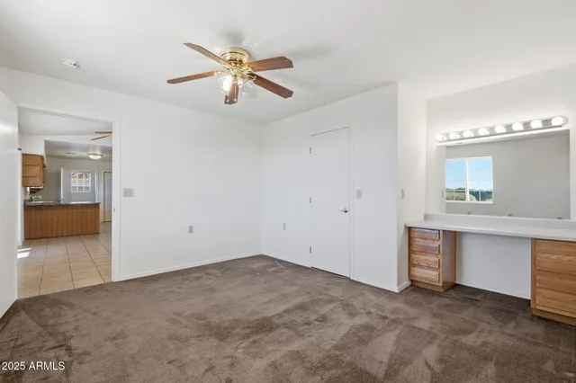 an empty room with closet and a chandelier fan