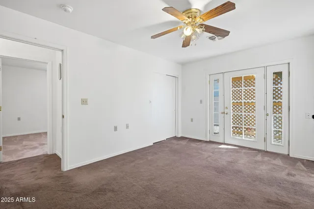 an empty room with closet and fan
