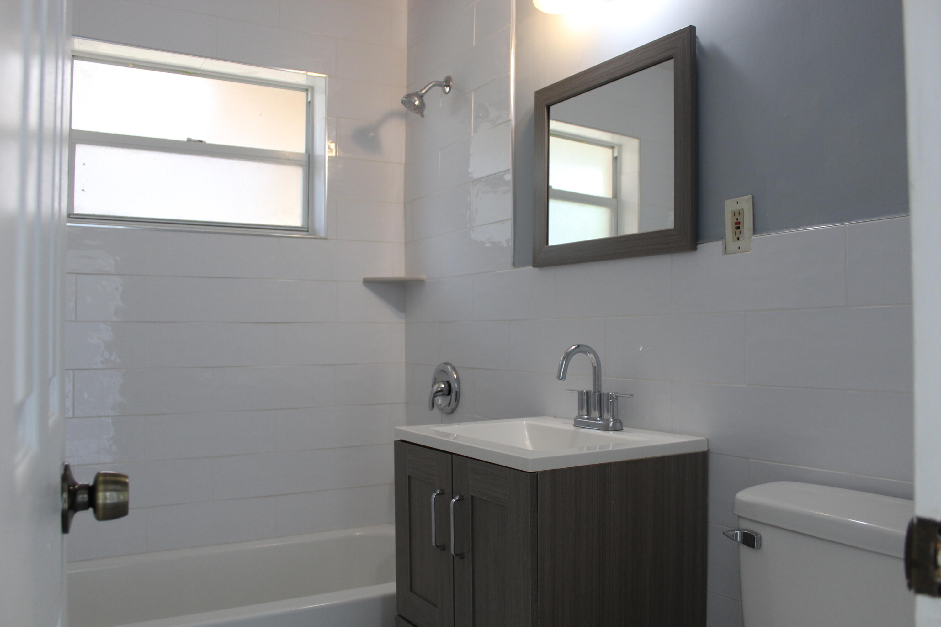 921 Pine Terrace Lake Worth Beach, FL 33460 - Photo 10 of 10 a bathroom with a sink toilet a mirror and shower
