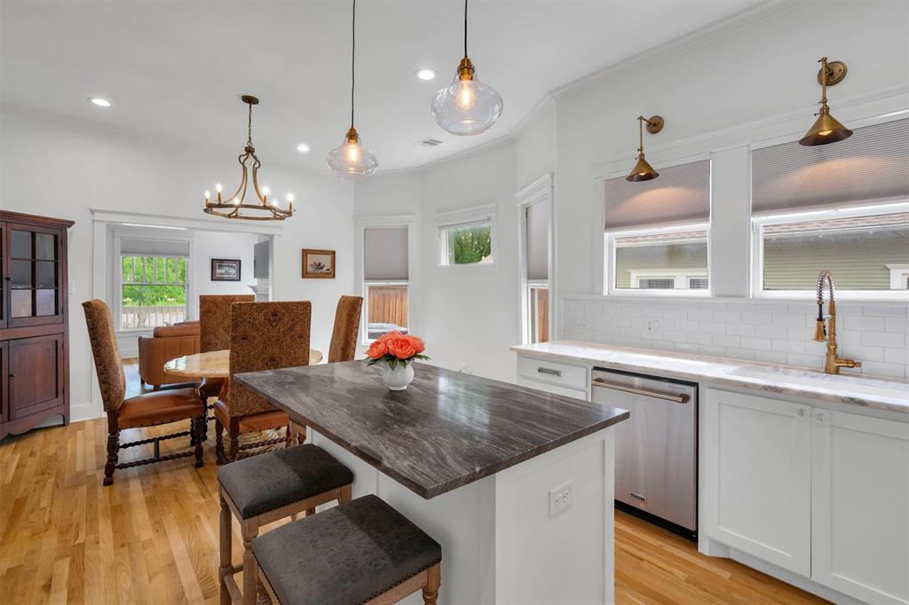 5727 Victor Street Dallas, TX 75214 - Photo 20 of 40 a open kitchen with a table chairs and wooden floor