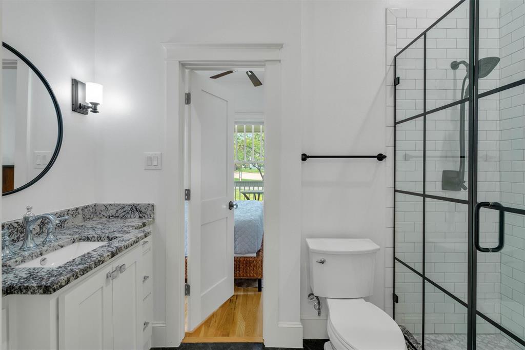 5727 Victor Street Dallas, TX 75214 - Photo 29 of 40 a bathroom with a granite countertop sink toilet and shower