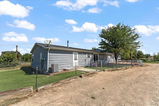a view of a house with a yard and a large tree