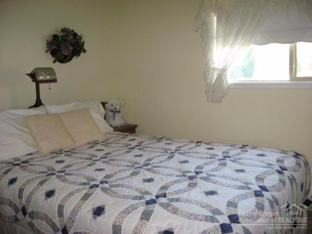 27103 Ridge Road John Day, OR 97845 - Photo 15 of 25 a bedroom with a bed and a chandelier