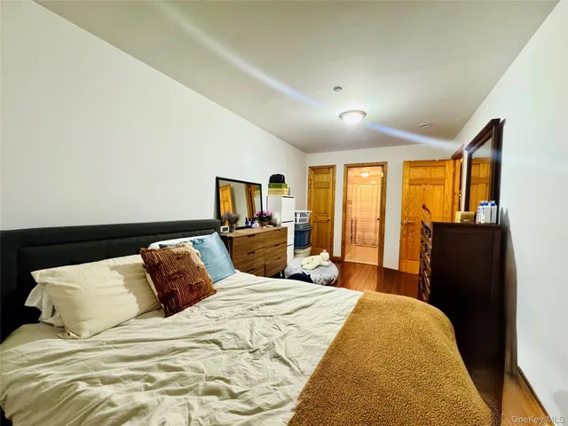a bedroom with a large bed and wooden floor