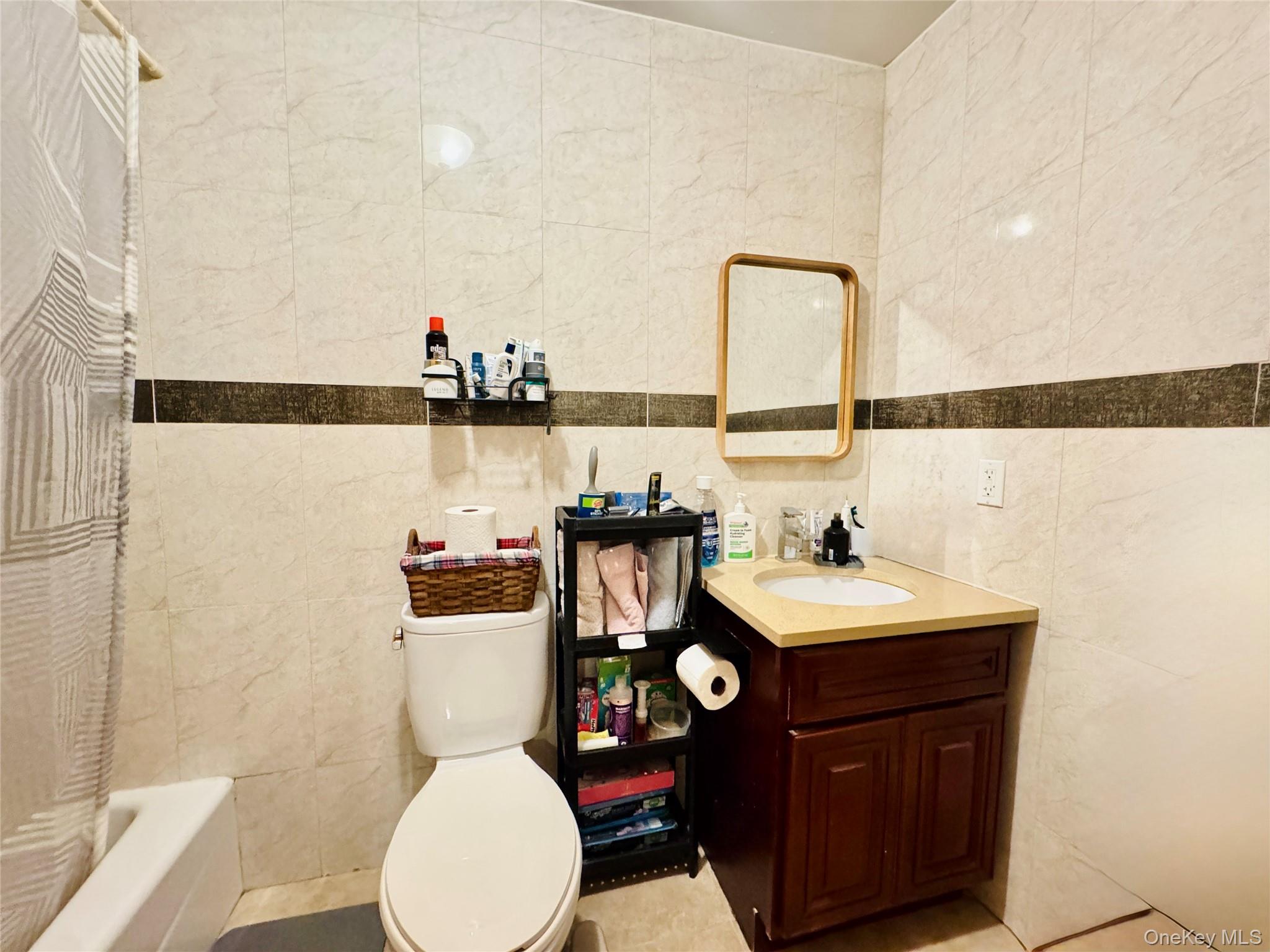 37-49 81st Street, Unit 3A Queens, NY 11372 - Photo 15 of 20 a bathroom with a sink mirror and toilet