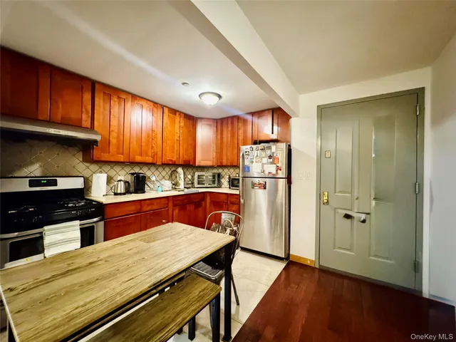 a kitchen with stainless steel appliances wooden floors and wooden cabinets