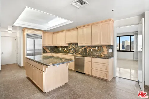 a view of kitchen with granite countertop white cabinets and sink