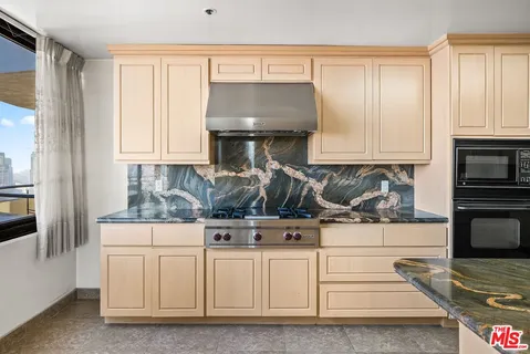 a view of a refrigerator in kitchen and an empty room