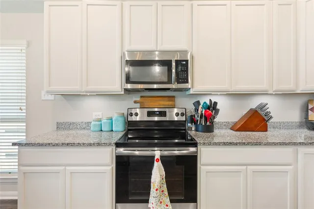 a kitchen with a stove and a white cabinets