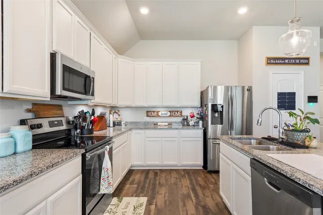 a kitchen with refrigerator a microwave and cabinets