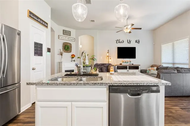 a kitchen with stainless steel appliances granite countertop a sink refrigerator stove and microwave