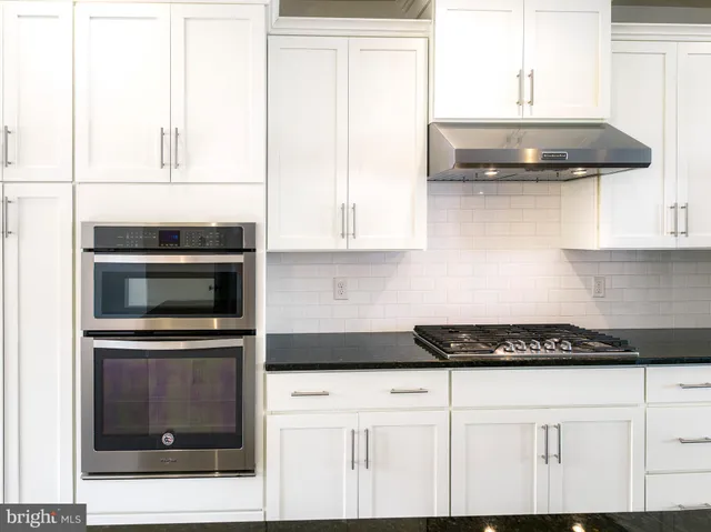 a kitchen with stainless steel appliances granite countertop a stove and a microwave