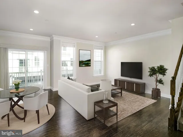 a living room with furniture a flat screen tv and a large window