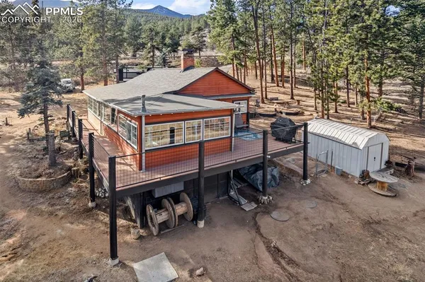 a view of a small house with roof deck front of house