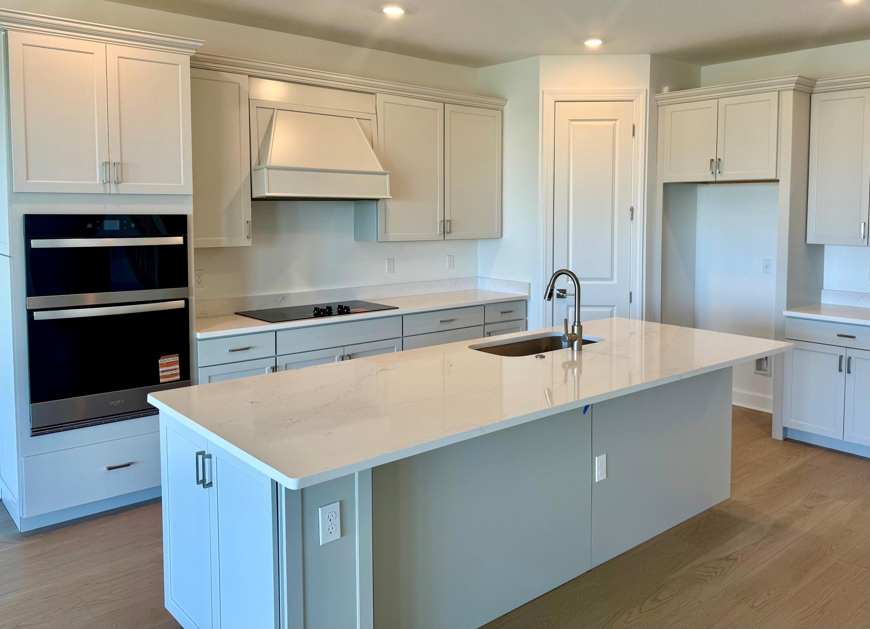 4340 Southwest Cornerstone Way, Unit WHITESTONE 136 Stuart, FL 34997 - Photo 10 of 34 a kitchen with kitchen island granite countertop a sink a stove and cabinets