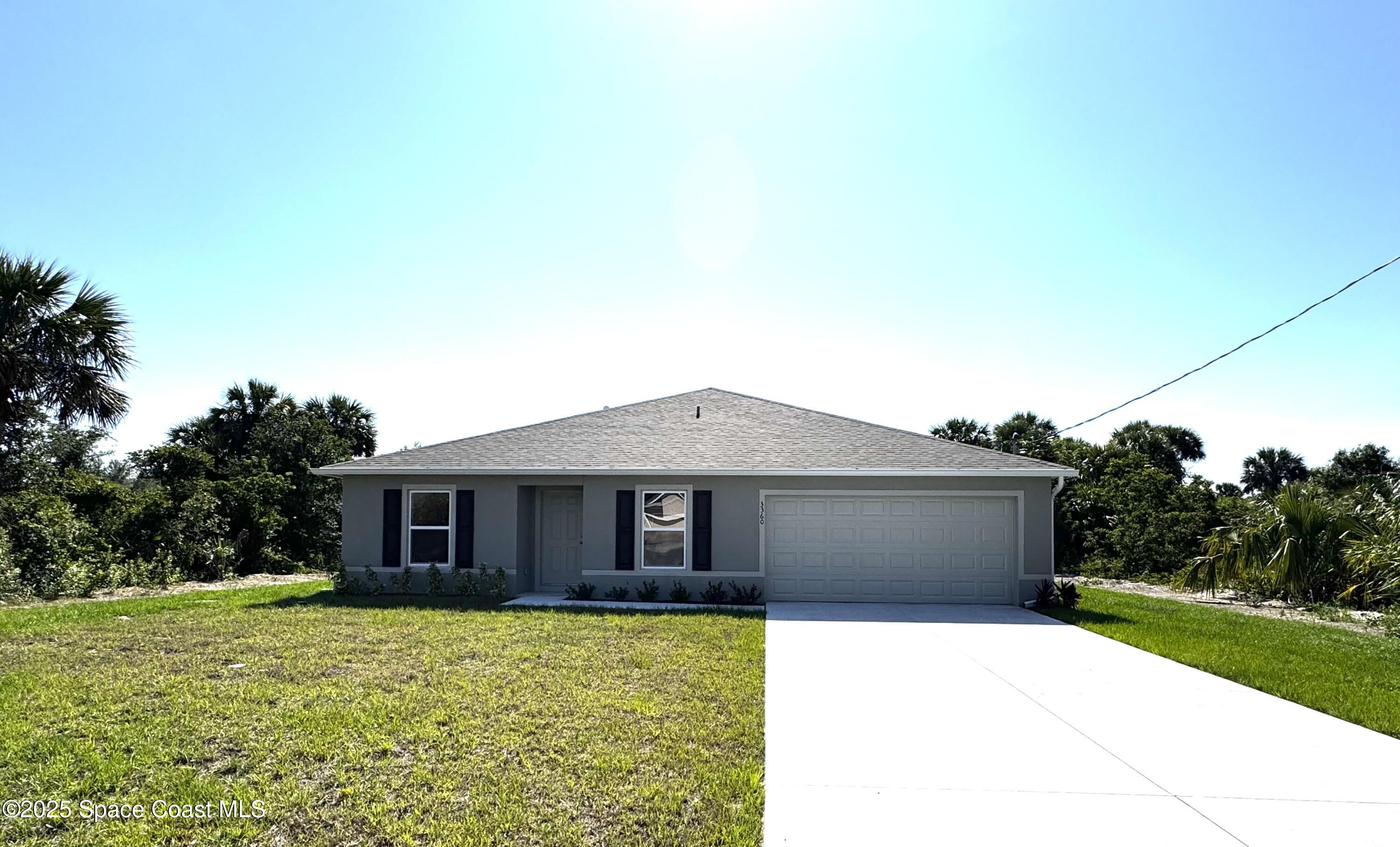 3360 Freedom Avenue Palm Bay, FL 32908 - Photo 3 of 3 a front view of a house with a garden