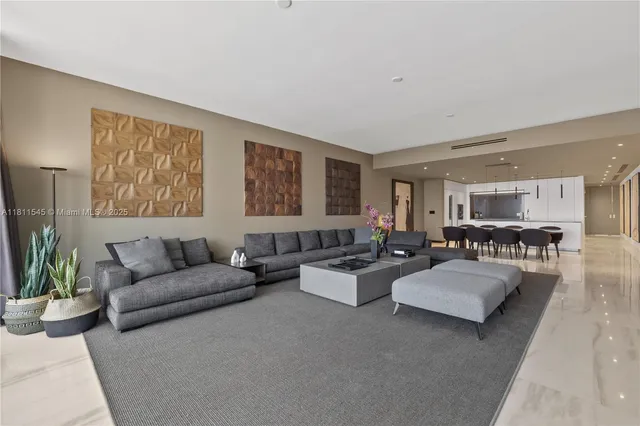 a living room with couches and a potted plant on a dresser