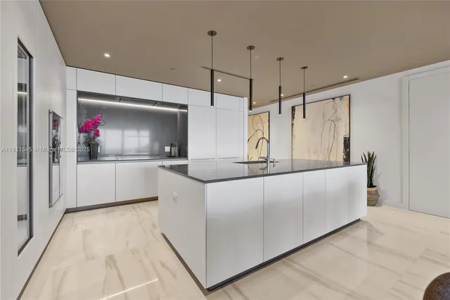 a large kitchen with kitchen island a large counter top stainless steel appliances and cabinets