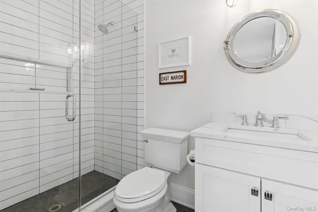 a bathroom with a granite countertop toilet sink and mirror