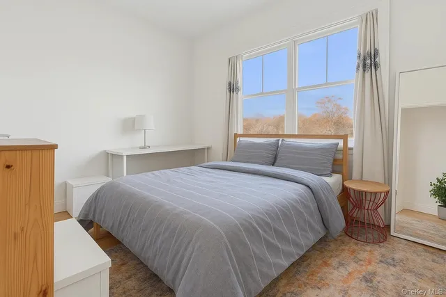 a bedroom with a bed and large window