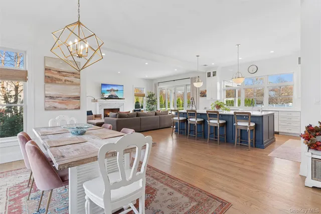 a dining room with wooden floor a chandelier a wooden table and chairs