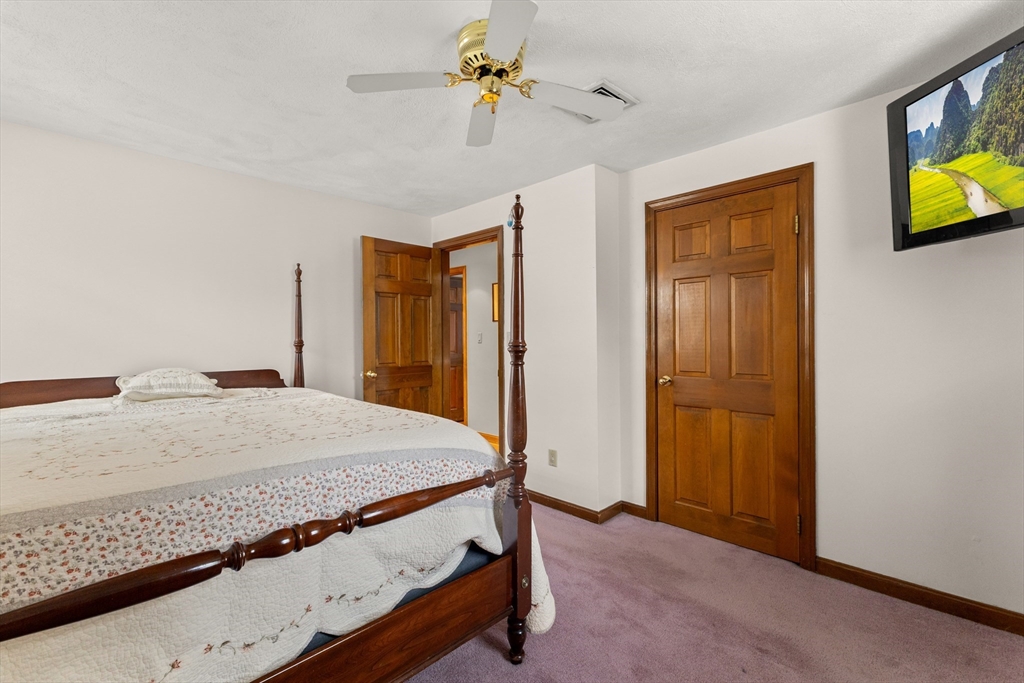 70 Dillingham Way Hanover, MA 02339 - Photo 26 of 42 a bedroom with a bed and a chandelier