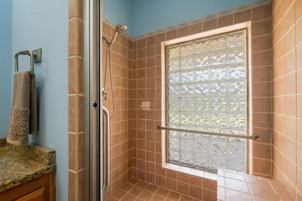 a bathroom with a granite countertop shower and a sink