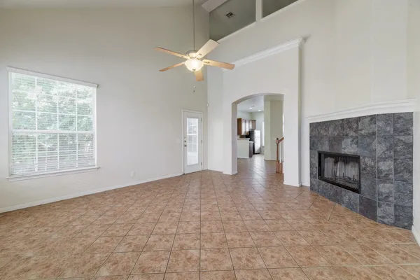 an empty room with windows and fireplace