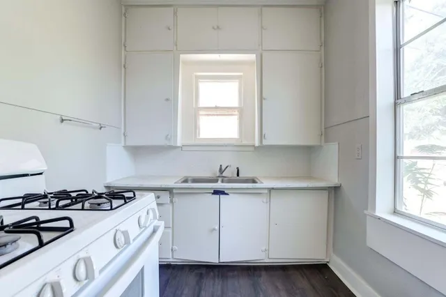 a kitchen with a sink stove top oven and cabinets