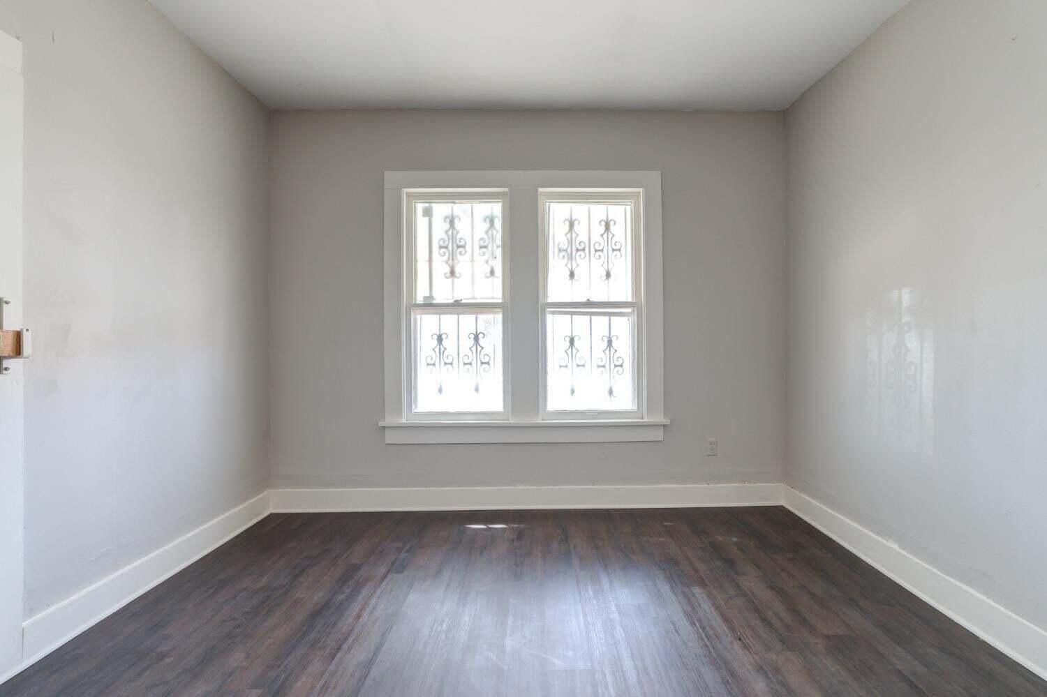 1918 18th Street Lubbock, TX 79401 - Photo 14 of 28 an empty room with wooden floor and windows