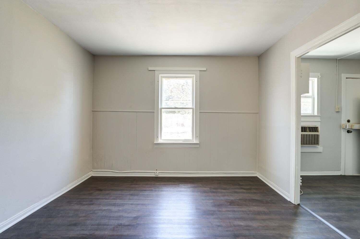 1918 18th Street Lubbock, TX 79401 - Photo 16 of 28 an empty room with wooden floor and windows