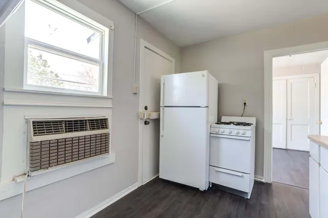 a kitchen with a refrigerator a stove and a window