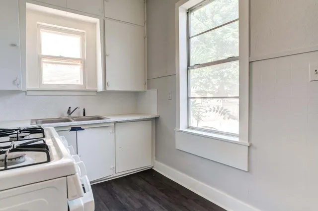 a view of a kitchen with sink and wooden floor