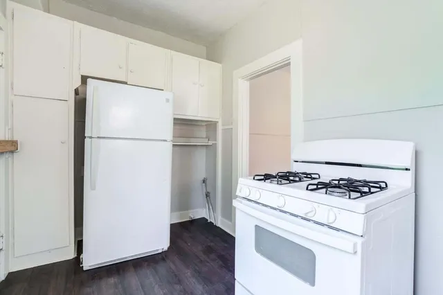 a white refrigerator freezer and a stove sitting inside of a kitchen