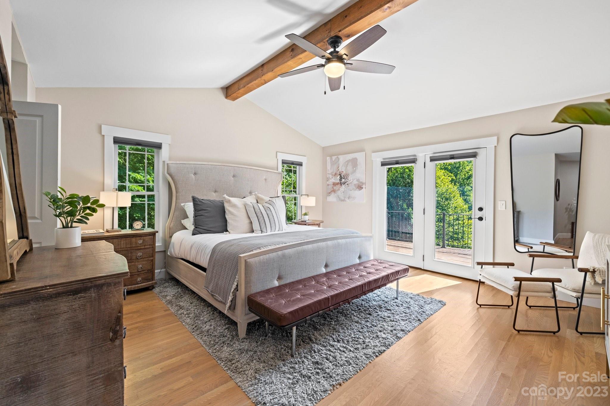 188 White Oak Gap Road Asheville, NC 28803 - Photo 18 of 48 a spacious bedroom with a bed a couch and a potted plant on the table