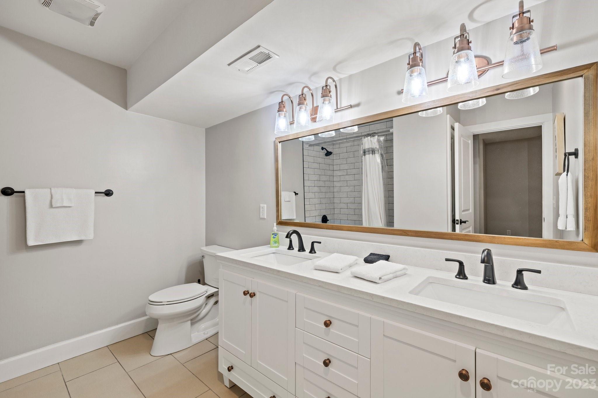 188 White Oak Gap Road Asheville, NC 28803 - Photo 30 of 48 a bathroom with a toilet sink double vanity and mirror