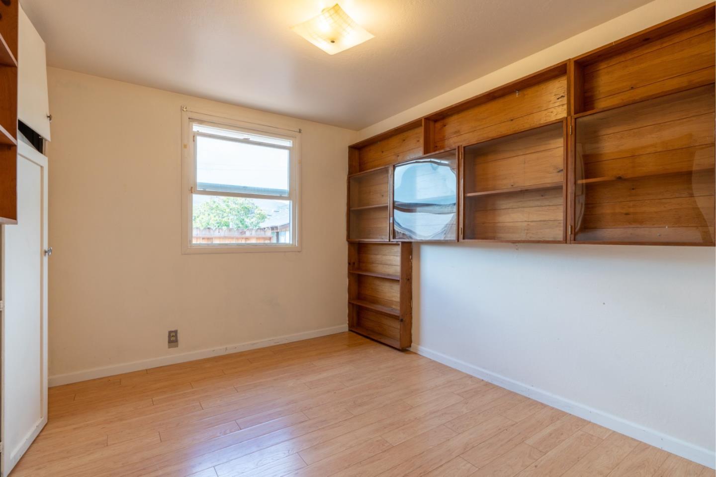 1139 Peralta Road Pacifica, CA 94044 - Photo 12 of 23 a view of an empty room with wooden floor and a window