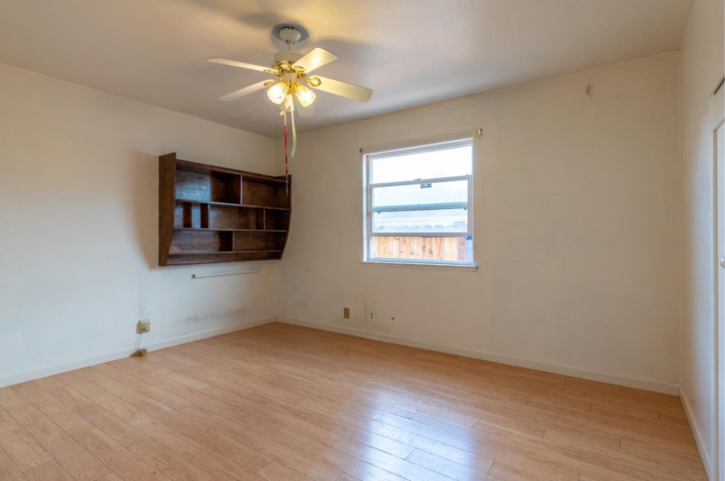 1139 Peralta Road Pacifica, CA 94044 - Photo 13 of 23 an empty room with wooden floor chandelier fan and windows